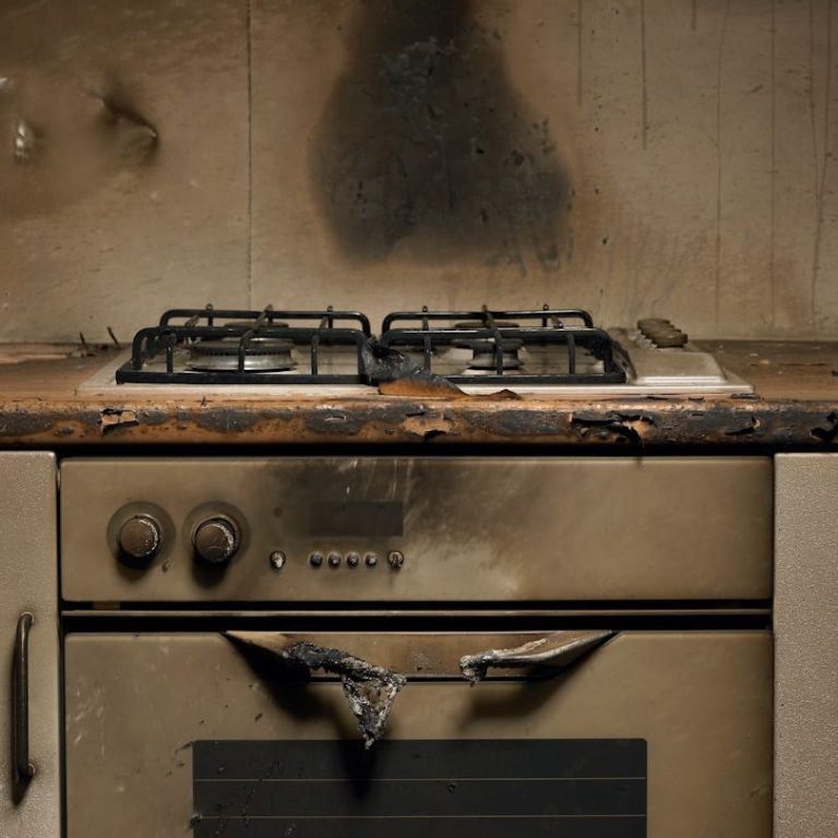 A damaged kitchen stove with burn marks and a charred surface.  Rent a mobile kitchen after fire, flood or other emergency